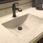 SFI cultured marble bathroom vanity sink top in a light cream color with speckles and a Wave sink bowl.