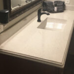 SFI cultured marble bathroom vanity sink top in a light cream color with speckles and a Wave sink bowl.