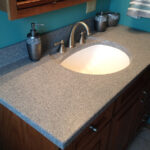 SFI two-toned, cultured marble bathroom vanity sink top with a white sink bowl and dark gray speckled vanity top.