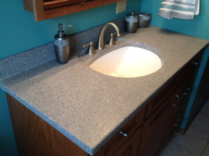 SFI two-toned, cultured marble bathroom vanity sink top with a white sink bowl and dark gray speckled vanity top.