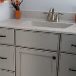 SFI cultured marble vanity sink top and backsplash installed in a light gray bathroom.