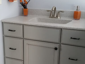 SFI cultured marble vanity sink top and backsplash installed in a light gray bathroom.