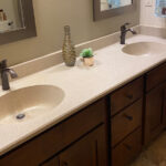 SFI cultured marble bathroom vanity sink top in a cream and light brown speckled color with two sinks.