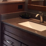 SFI two-toned, cultured marble bathroom vanity sink top with a white sink bowl and dark brown speckled vanity top.