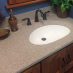 SFI two-toned, cultured marble bathroom vanity sink top in a light brown speckled color with a white sink bowl.