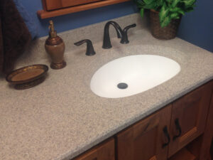 SFI two-toned, cultured marble bathroom vanity sink top in a light brown speckled color with a white sink bowl.