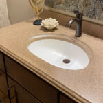 SFI two-toned, cultured marble bathroom vanity sink top in a light brown speckled color with a white sink bowl.